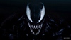 Close up on Venom baring his teeth, with a black background.